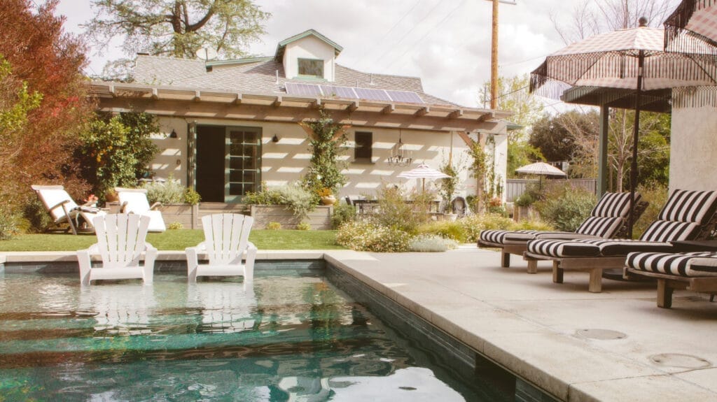 wooden seats by pool with parasols